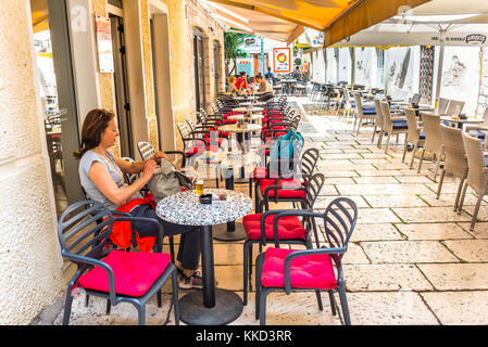 La donna non identificato di bere birra presso il cafe in Sibenik,una popolare destinazione turistica per architettura storica,strette strade di pietra in Croazia.Maggio 26,20 Foto Stock