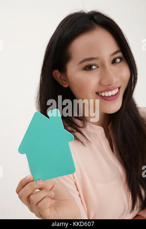 Donna malay tenendo una casa di cartone sagomati Foto Stock