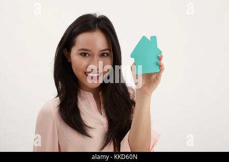 Donna malay tenendo una casa di cartone sagomati Foto Stock