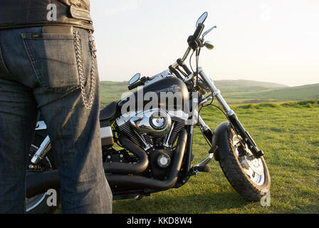 Uomo in piedi accanto a un Harley Davidson Moto in campagna Foto Stock