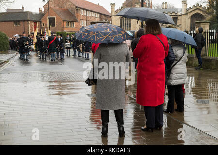 Vista posteriore di persone che guardano la pipe band & veterani di guerra allineando prima dell inizio della sfilata commemorativa - da York Minster North Yorkshire, Inghilterra, Regno Unito. Foto Stock