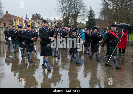 Pipe Band marching & giocando in pioggia durante la sfilata vicino a York Minster sul cinquantesimo anniversario della British ritiro da Aden - Yorkshire, Inghilterra, GB, UK. Foto Stock