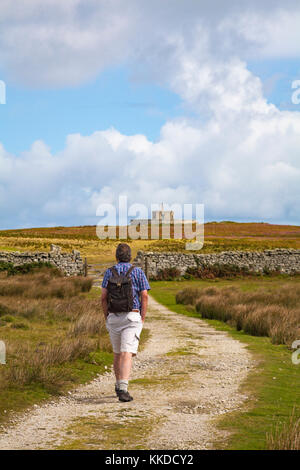 Uomo che cammina lungo il percorso verso Tibbetts, precedentemente Admiralty Lookout post, a Lundy Island, Devon, Inghilterra Regno Unito nel mese di agosto Foto Stock