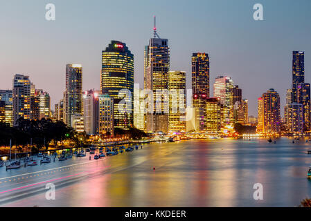 Skyline della città di Brisbane al crepuscolo con alti edifici illuminati che si riflettono sul fiume Foto Stock