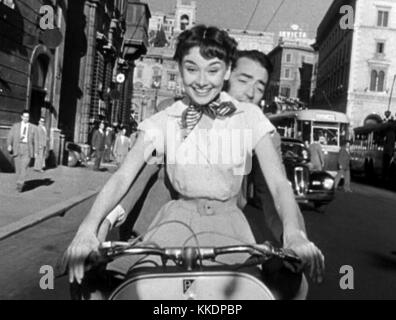 Un'immagine del film "Vacanze Romane", con Audrey Hepburn e Gregory Peck a bordo di una Vespa per le strade di Roma, catturando il momento iconico del classico film comico romantico del 1953. Foto Stock