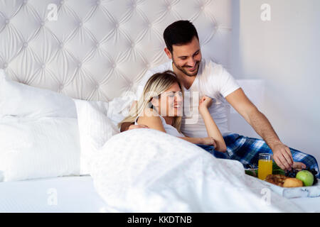 Giovane coppia attraente avente la colazione a letto Foto Stock