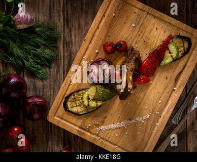 Pezzi di carne fritta e verdure su un tagliere, vista dall'alto Foto Stock