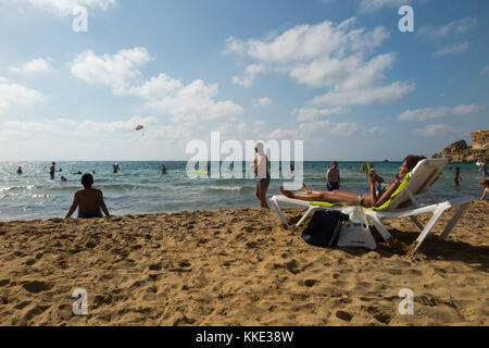 Il mare e la spiaggia di sabbia con turisti / lucertole da mare gente che si diverte nuotare e prendere il sole, al Golden Bay Beach, vicino a Mellieha. Malta. (91) Foto Stock