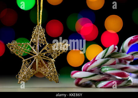 Un celebrativo stella di natale su un tavolo di legno. le decorazioni di Natale sullo sfondo di luci di Natale.Sfondo nero Foto Stock