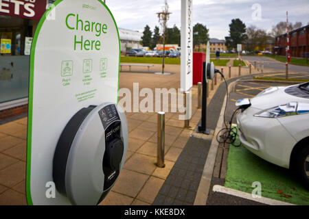 Burtonwood shopping centre in Warrington, un elettrico Nissan Leaf auto parcheggiate in un parcheggio dedicato bay per la ricarica della batteria Foto Stock