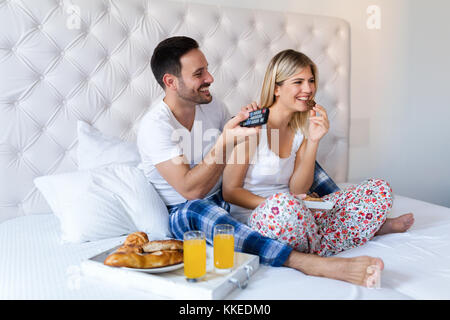 Giovane coppia attraente avente la colazione a letto Foto Stock