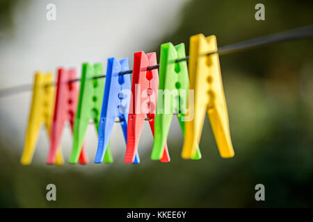 Pioli colorati appesi stendibiancheria Foto Stock