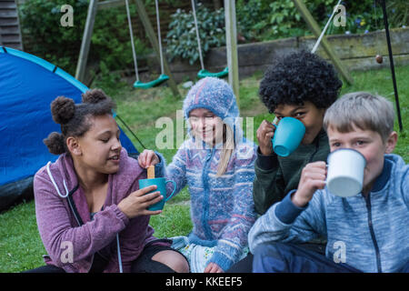 Big wild sleepout caso pix . immagini di giovani ragazzi/ i bambini e i genitori nel loro giardino sul retro da circa la metà del pomeriggio fino a tarda sera-tempo, godendo di attività, come ad esempio fare un den, guardando i bug, mettendo fuori il cibo per cani per il riccio, di tostatura marshmallows intorno a un falò, falena trappola, cercando per animali notturni. Foto Stock