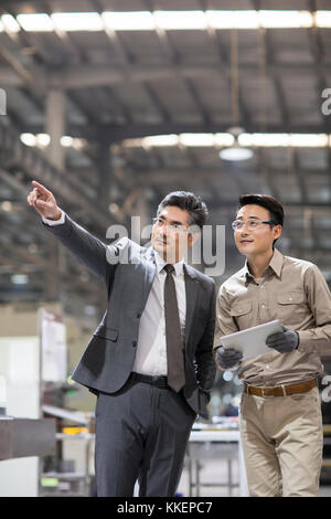 Imprenditore cinese e l'ingegnere parlando in fabbrica Foto Stock