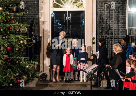 Londra, UK . 06 Dic, 2017. Il primo ministro Theresa Maggio esce per accendere le luci con alcuni bambini della scuola - di Downing Street albero di Natale luci sono accese serenate da un tradizionale coro dei bambini cantando canti natalizi. Credito: Guy Bell/Alamy Live News Foto Stock