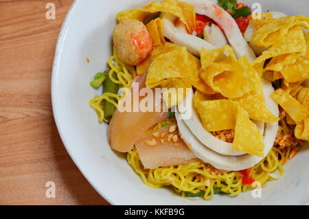 Cinese a secco di noodle all'uovo con carne di maiale a sfera e decapati squid topping gnocco fritto sul recipiente Foto Stock