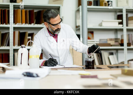 Vista in ingegnere in laboratorio esamina le piastrelle di ceramica Foto Stock