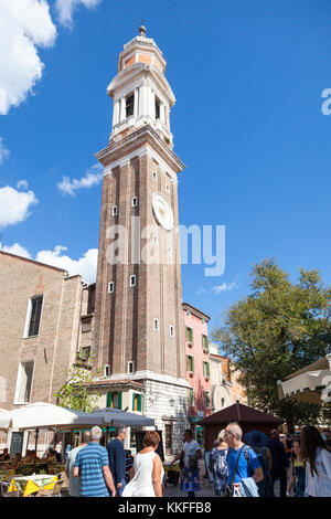 Il campanile del secolo VII Chiesa dei Santi Apostoli in Cannaregio, Venezia, Italia in Campo Santi Apostoli con i turisti a piedi al di sotto di Foto Stock