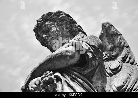 Un pensieroso angelo brucia la sua testa nel dolore per una grave nella storica del cimitero di Hollywood in Richmond, Virginia. Foto Stock