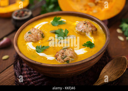 Deliziosa crema di zuppa di zucca con polpette di carne di tacchino carne macinata in una ciotola su una tavola di legno. vista dall'alto. La Giornata del ringraziamento. Foto Stock