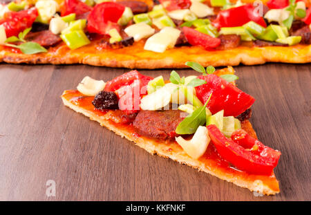 Ortaggi freschi e salsiccia sulla pizza sandwich. messa a fuoco selettiva al centro della fetta Foto Stock