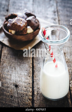 Vaso di vetro con latte e biscotti in background,fuoco selettivo Foto Stock