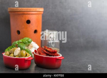 Olive e pomodori secchi e spezie su uno sfondo di pietra Foto Stock