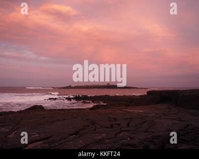 Il sole sorge su Atlantica selvaggia a modo di Doolin Pier, County Clare, Irlanda ruotando il rock pools uno squarcio di colore rosso. Foto Stock