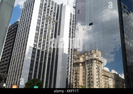 Le riflessioni di nuvoloso cielo blu e il vecchio edificio in un nuovo ufficio di vetro business building, Avenida Paulista (Paulista Avenue), Sao Paulo, Brasile Foto Stock