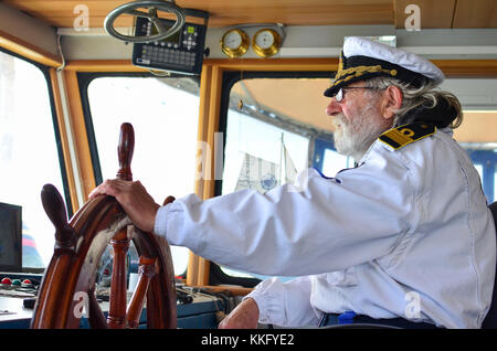 Navigazione della nave, capitano esperto, vecchio cane del mare con i capelli grigi e la barba sul suo posto di lavoro, nave cabine di navigazione Foto Stock