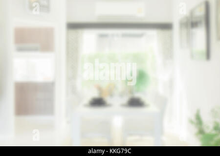 Sfocare lo sfondo bianco del tavolo da pranzo nella sala da pranzo moderna Foto Stock