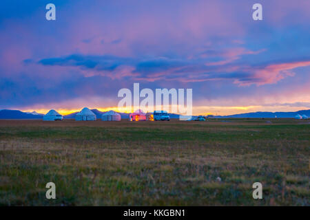 Yurta e le montagne intorno a song kul lago in una luce del tramonto, il Kirghizistan Foto Stock