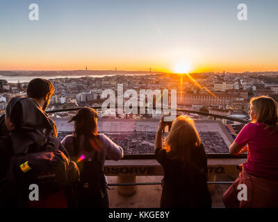 Lisbona, Portogallo - 19 novembre 2017: turisti al belvedere della Madonna del Colle Viewpoint, guardando il Cityscape di Lisbona al tramonto. Foto Stock