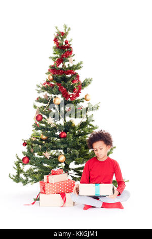 Razza mista boy vicino albero di natale Foto Stock