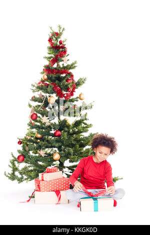 Razza mista boy vicino albero di natale Foto Stock