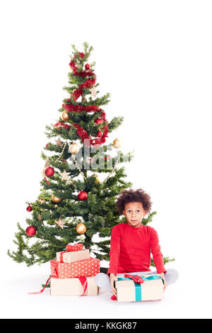 Razza mista boy vicino albero di natale Foto Stock