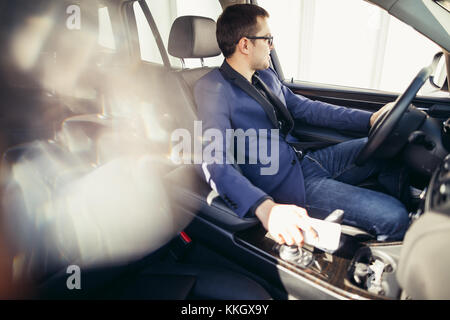 Ritratto di un bel sorriso business man alla guida della sua auto Foto Stock