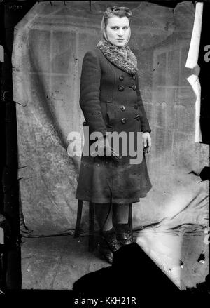 Questa fotografia, scattata il 17 dicembre 2013, ritrae una donna che cattura un momento della vita quotidiana in un ambiente urbano. L'immagine riflette una rappresentazione semplice ma significativa della vita moderna. Foto Stock