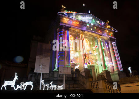 Tate Britain, Londra, Regno Unito. 1 dicembre, 2017. 06.30am. Alan Kane ha ideato un nuovo ed entusiasmante lavoro per Tate Britain iconici facciata per contrassegnare la stagione di Natale. A casa per Natale trasforma il neo-classico della parte esterna della galleria in un display brillante di off-ripiano decorazioni. Una mostra a disposizione di arresto del LED Babbo Natale, renne, pupazzi di neve e alberi di Natale, insieme con 'buon natale' e 'Santa fermare qui' segni adornano il Vittoriano ingresso porticato. Credito: Malcolm Park/Alamy Live News. Foto Stock