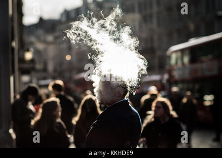 Londra, Regno Unito. 1 dicembre, 2017. Regno Unito Meteo: un uomo vapes su Oxford Street che produce grandi nuvole di vapore potenziata dalla fredda aria invernale e il sole del pomeriggio. Credito: Guy Corbishley/Alamy Live News Foto Stock