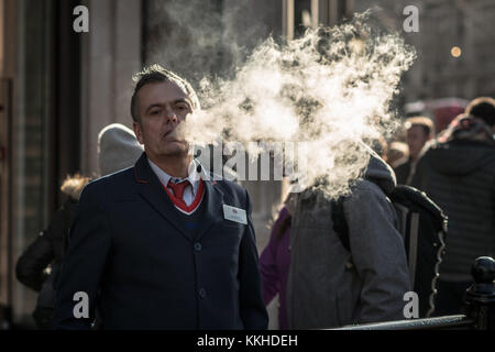 Londra, Regno Unito. 1 dicembre, 2017. Regno Unito Meteo: un uomo vapes su Oxford Street che produce grandi nuvole di vapore potenziata dalla fredda aria invernale e il sole del pomeriggio. Credito: Guy Corbishley/Alamy Live News Foto Stock