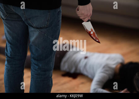 Penale con il coltello e il corpo morto a scena del crimine Foto Stock