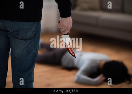 Penale con il coltello e il corpo morto a scena del crimine Foto Stock