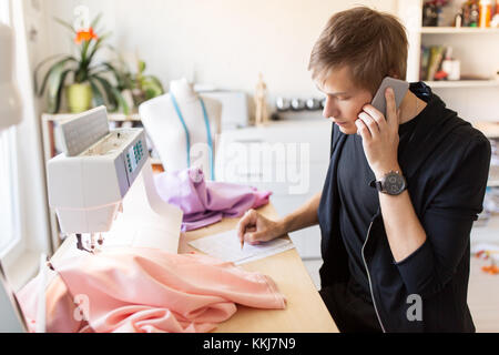Designer di moda chiamando sullo smartphone in studio Foto Stock