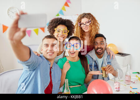 Happy team tenendo selfie a festa in ufficio Foto Stock