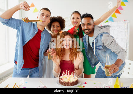 Felice i colleghi con torta in ufficio festa di compleanno Foto Stock