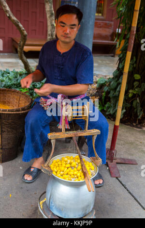 Bangkok, Tailandia. Materie di ebollizione bozzoli di seta, Jim Thompson House dimostrazione. Foto Stock