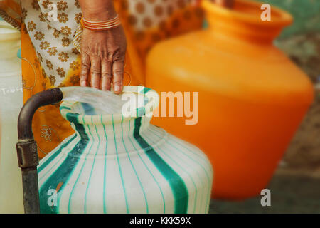 Indian acqua tubo di supporto di riempimento in materiale plastico una pentola d'acqua. Foto Stock