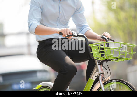 Giovane uomo cinese in sella ad una bici condividi Foto Stock