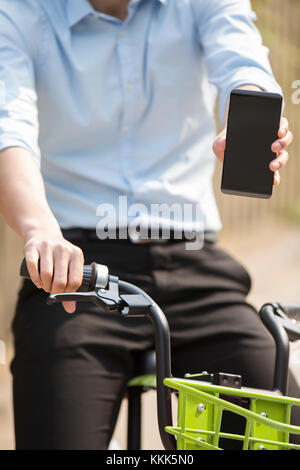 Giovane uomo cinese in sella ad una bici condividi Foto Stock